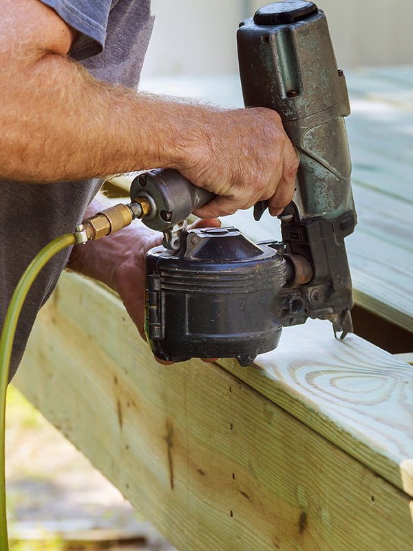 contractor hands with nailgun close up building a house deck corryton tn