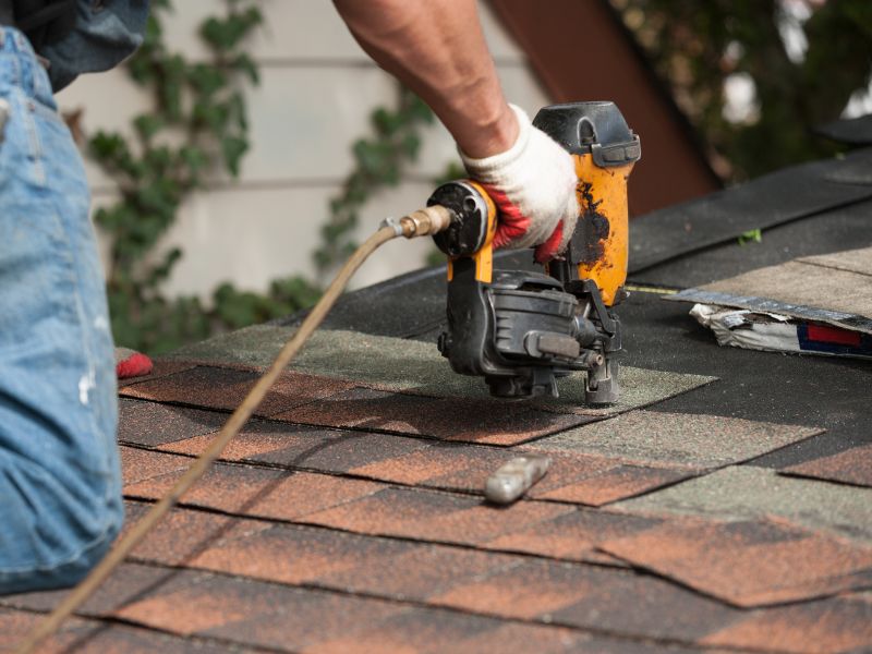 roofer repairing asphalt shingles at house roof corryton tn